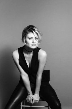 Güzel sarışın bir kadın, kamera, düz studio arka plan karşı ciddi seyir stüdyo portre kadar kapatın