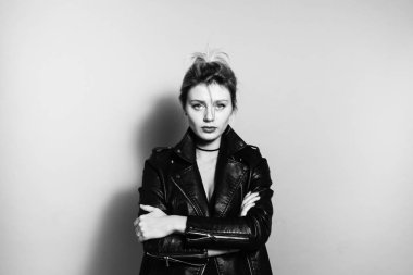 Portre fotoğraf makinesi, düz studio arka plan bakarak siyah bisikletçinin ceket bir güzel sarışın kadın, kapatmak