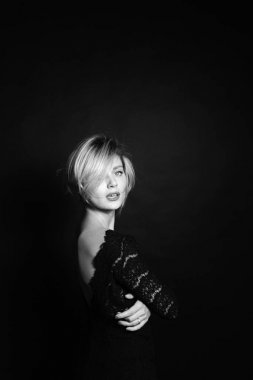 Yarım tur kameranın düz studio arka plan ayakta açık arka, dantel elbise genç bir kadın portresi kapatın