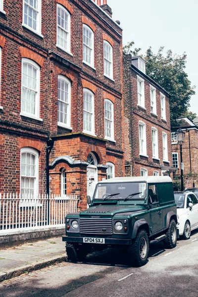 Land Rover Defender Londra 'nın bir sokağına park etmiş.