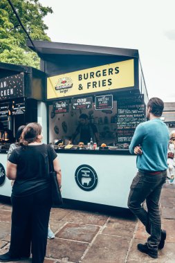 Turistler Londra 'daki Camden Market' te bir marketten yiyecek alıyorlar.