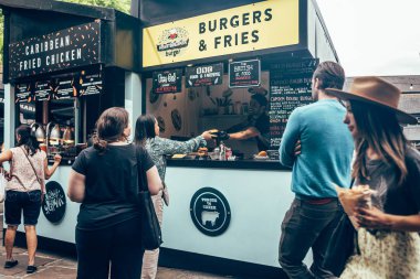 Turistler Londra 'daki Camden Market' te bir marketten yiyecek alıyorlar.
