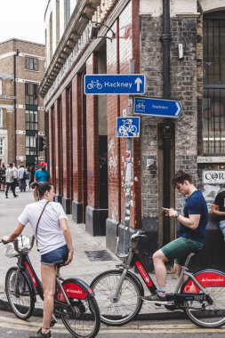 Londra 'da bir sokakta Santander Bisikletleri kiralayan genç bir çift.