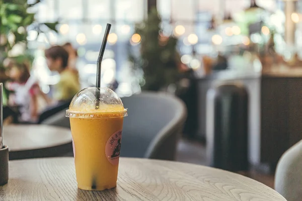 Londra / İngiltere-1 / 08 / 18: dünyanın dört bir yanında meyve suyu ve kahve dükkanları zinciri olan Joe & The Juice cafe 'den alınmış ve bir masanın üzerinde duran bir pipetle plastik bardak meyve suyunu kapatın