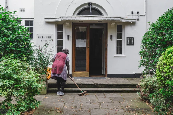Londra / İngiltere-30 / 07 / 18: Londra 'da bir apartmanın terasında temizlik yapan bir kadın