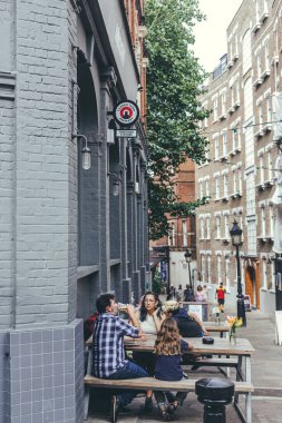 Londra / UK- 30 / 07 / 19: Hampstead Heath Caddesi 'ndeki Horseshoe Bar' ın hemen dışındaki masada oturan bir aile. Londra 'nın en pahalı konutlarından birine sahip.