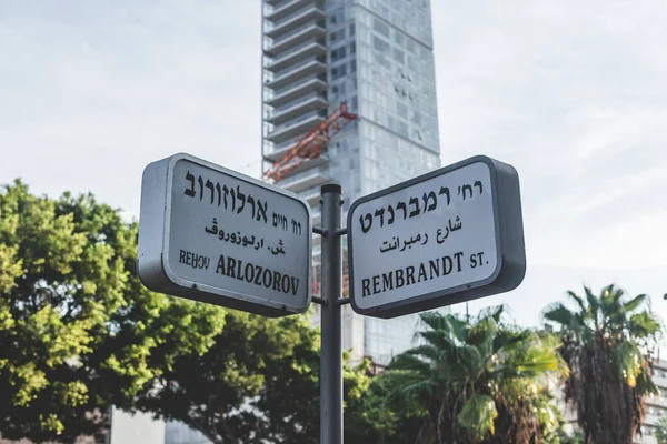 Tel Aviv, İsrail 'de Arlozorov ve Rembrandt Caddesi tabelaları. Sokak isimleri genellikle kavşaklarda asılıdır ve genellikle karşıdan karşıya geçen kişileri belirleyen dikey yönelimli çiftlerdir.