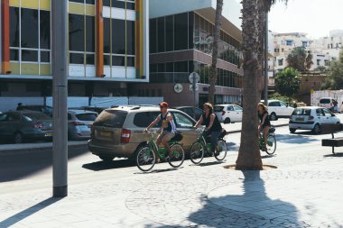 Tel Aviv / Israel-10 / 10 / 18: Tel Aviv 'de bir sokakta bisiklet paylaşan insanlar. Kamu bisikleti paylaşımı, motosikletlerin kısa vadeli olarak ortak kullanımlar için kullanılabilir hale getirildiği bir hizmettir.