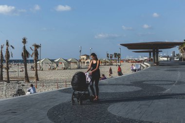 Tel Aviv / İsrail-10 / 10 / 18: Tel Aviv 'de gezinti güvertesinde bebeği olan genç bir anne