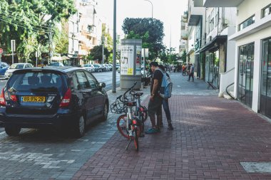 Tel Aviv / Israel-12 / 10 / 18: Tel Aviv 'de bir sokakta limansız motosiklet kiralamayı düşünen turistler. Mobike merkezi Çin 'de bulunan dünyanın en büyük bisiklet paylaşım operatörlerinden biridir.