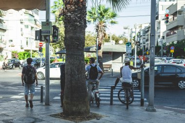 Tel Aviv / İsrail-12 / 10 / 18: Tel Aviv 'de bir sokakta yeşil trafik ışığı bekleyen motosikletli insanlar