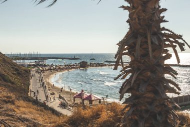 Tel Aviv / İsrail-12 / 10 / 18: Hilton Sahili 'nde dinlenen ve Tel Aviv' deki Akdeniz gezinti güvertesi boyunca yürüyen insanlar
