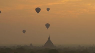 Güneş doğarken Bagan ovasının üzerinde sıcak hava balonu, Myanmar 