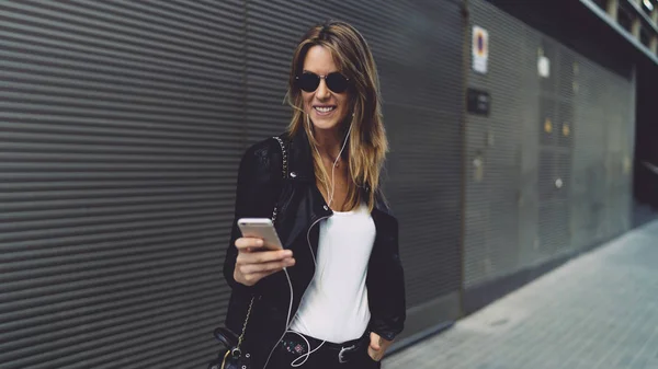 Jovencita Alegre Gafas Sol Sonriendo Mientras Lee Mensajes Amigo Elegante —  Fotos de Stock