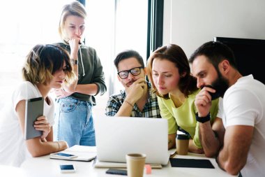 Grup genç iş adamları dizüstü bilgisayardaki e-posta ana yatırım şirketten kendi iş için okuyor. Ekonomi analist ekibinin yönetimi için üç aylık raporu hazırlanıyor.