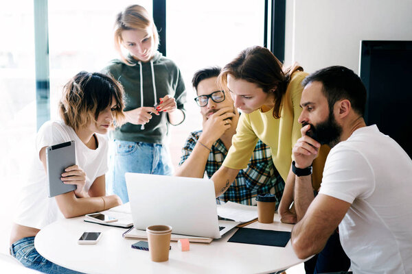 Процесс мозгового штурма во время встречи коллег. Группа хипстеров думает над новым проектом в ярком современном офисе и. Друзья используют различные электронные устройства
.