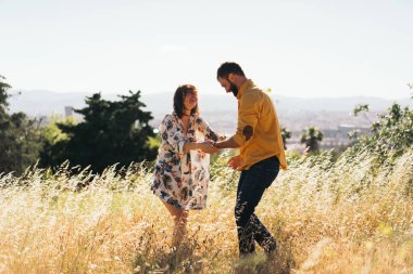 Romantik bir çift sıcak güneşli yaz çayır ortasında eğleniyor gün keyif alıyor. Bir erkek ve bir kadın aşık açık havada güne harcama vardır. Yeni evli genç bir çift portresi.