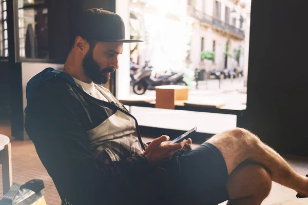 Skäggig Man Kontrollerar Posten Smartphone Medan Sitter Ett Kafé Staden — Stockfoto