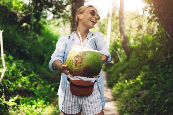 Blond Turistické Dívka Nabízí Kokosový Koktejl Pozadí Zelené Džungle Zelený — Stock fotografie