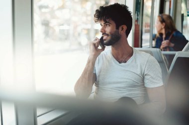 Genç freelancer adam bir şehir tramvay otururken genel wi-fi için bağlı bir akıllı telefon çağrı iş yaşıyor. Çekici modeli göz sakallı adam cep telefonuyla arkadaşlarınızla sohbet.