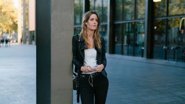 Girişimci kadın yanında duran sokak arka planda smartphone arıyor. Genç beyaz kadın ortakları ile dinlenme açık havada yaparken cep telefonuyla konuşuyor.