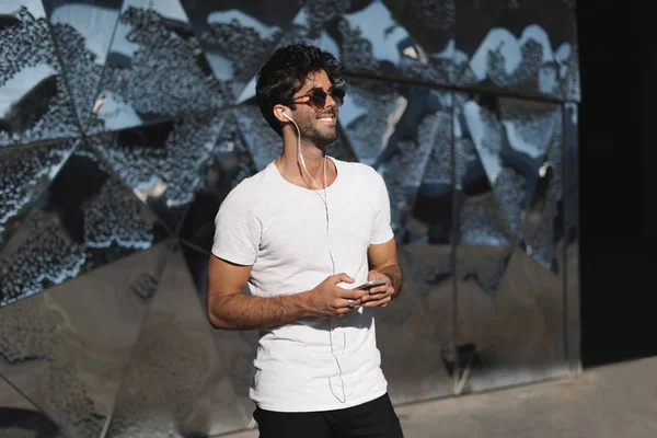 Jovem Barbudo Uma Camiseta Branca Branco Ouve Música Telefone Celular — Fotografia de Stock