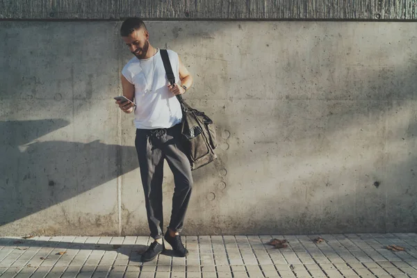Νέοι Γενειοφόρος Άνδρας Φορώντας Κομψά Ρούχα Στέκεται Ένα Smartphone Δίπλα — Φωτογραφία Αρχείου