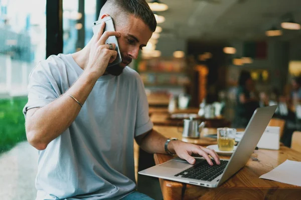 Handsome Young Man Having Conversation Mobile Phone While Working Remotely Stock Image