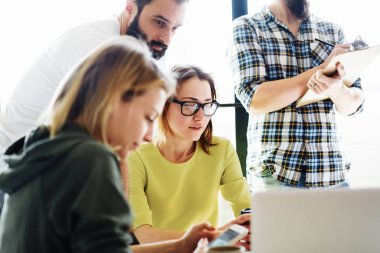 Modern başlangıç genç yöneticileri iş stratejisi gelecek yıl için modern ve aydınlık ofiste görüşüyorlar. Hipsters elektronik cihazlar ile toplantı sırasında oturuyorsun.