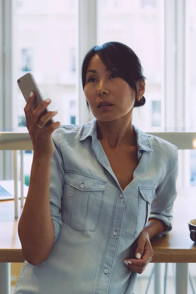 Attraktiv Asiatisk Kvinne Med Tilfeldige Klær Leser Beskjeder Mobilen Mens – stockfoto