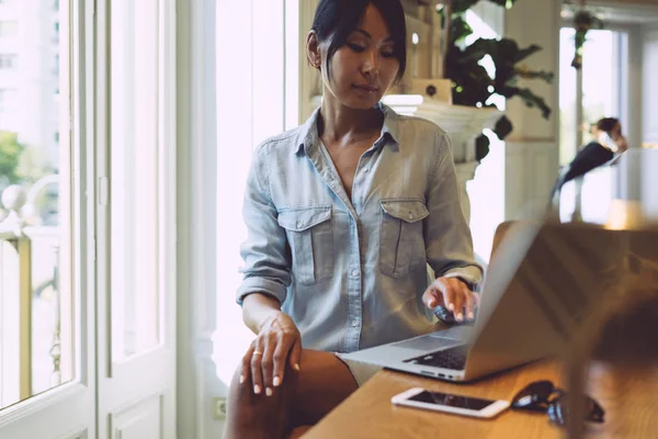年轻的商业妇女是在一个现代化的 Coworking 空间与智能手机和便携式电脑连接到 国际亚裔学生女性正在用笔记本电脑在线学习 — 图库照片