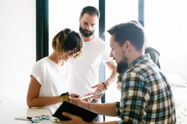 Satış yöneticileri ekip son dijital haber serbest zaman sırasında modern coworking evinde tartışıyor. Genç serbest yeni iş fikirleri proje yeni başlangıç için görüşüyorlar.