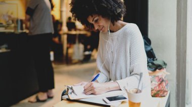 Bir hafta sonu günde bir modern şehir kafede otururken diploma iş için fikirler yazma şık kıyafetlerle akıllı uluslararası öğrenci erkek. Freelancer çözümlenirken piyasa verileri.