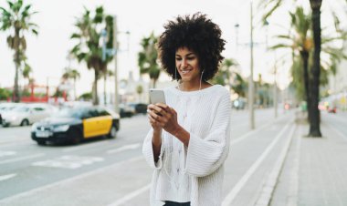Serbest meslek sahibi kadın aradı bir taksi ile bir cep telefonu uygulama gülen öğrenci kız açık havada rahatlatıcı bir müzik ile indirilen ve bir akıllı telefon üzerinde oynanan online programları için bekliyor.