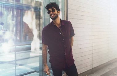 Modaya uygun kıyafet ve bir kenara Avrupa şehri sokak gezinme sırasında seyir giyen güneş gözlüğü şık hipster adam portresi giymiş. Kentsel ortamda yürüyüş yakışıklı genç erkek.