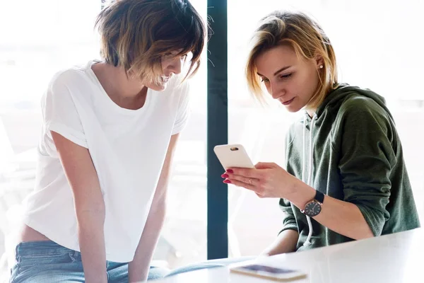 Duas Amigas Estão Assistindo Fotos Tela Celular Dois Jovens Empreendedores — Fotografia de Stock