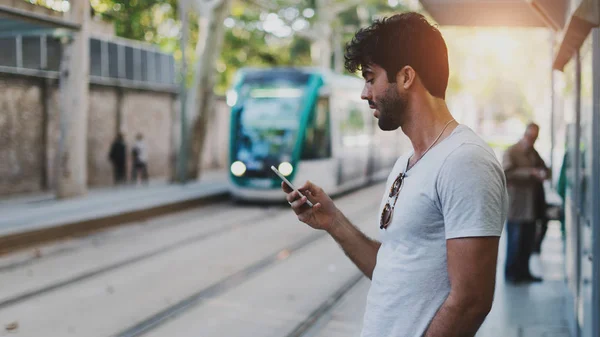 携帯電話からブログに書く現代旅行ブロッグ更新者は 新しい場所を探索しながらインターネットに接続 留学生のスマート フォン上のアプリ経由で公共交通機関の時刻表をチェック — ストック写真