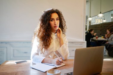 Not Defteri'nde laptop ile masada otururken yapma güzel genç kadın