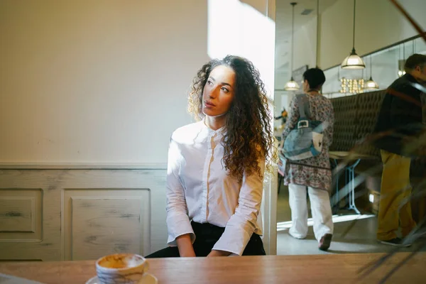 Młoda Atrakcyjna Kobieta Siedząc Kawiarni Tle Białej Ściany — Zdjęcie stockowe