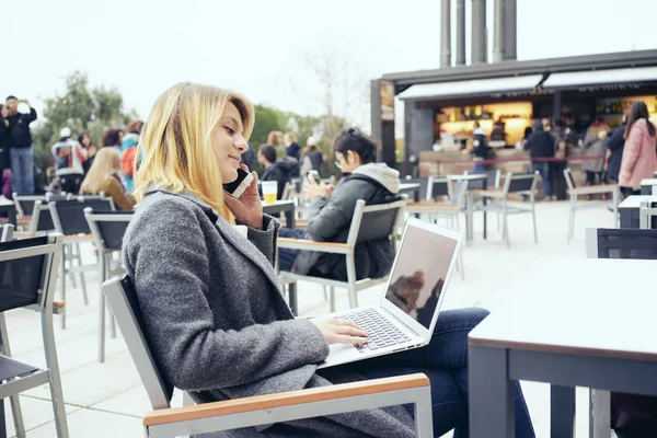 ปภาพของน จสาวท สวยงามถ อแล อปพกพา ขณะท งอย ในร านกาแฟข างนอก — ภาพถ่ายสต็อก