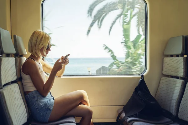 Wanita Muda Menggunakan Smartphone Kereta Bergerak Dekat Jendela — Stok Foto