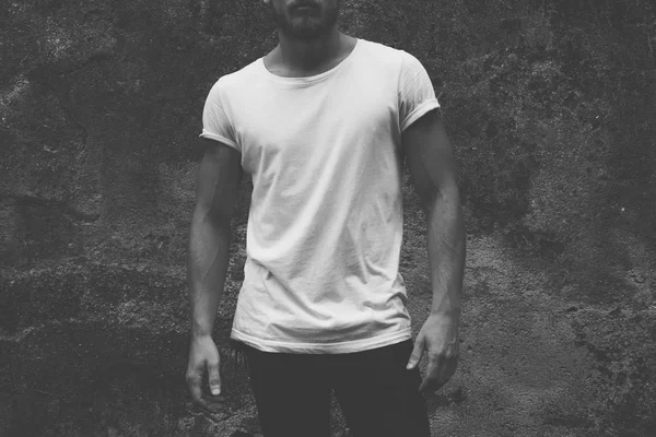 筋コンクリートの暗い背景 正面に空白の白い シャツの若い男 — ストック写真
