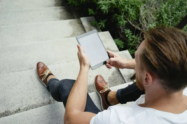 階段に座ってデジタル タブレットを使用してハンサムな若い男 — ストック写真