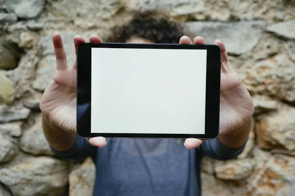 young woman holding tablet with white empty screen