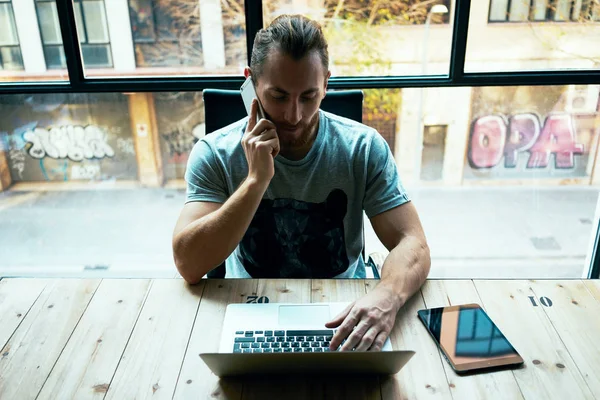 Fiatal Üzletember Miközben Beszélt Smartphone Irodában Dolgozik Laptop — Stock Fotó
