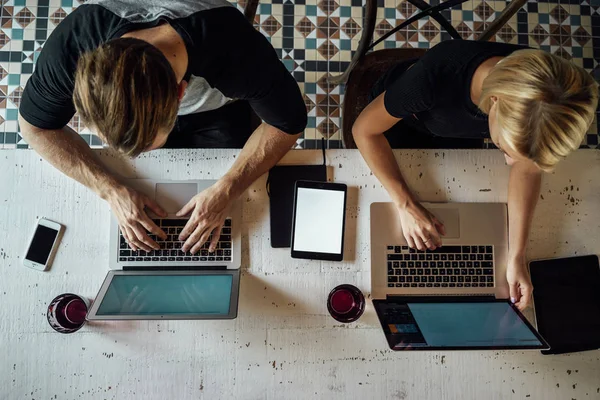 Top view of people working with laptops, smartphones and tablets with blank empty screen