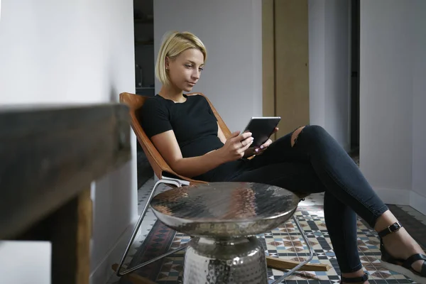young female writes in a blog on her digital tablet in a vintage interior