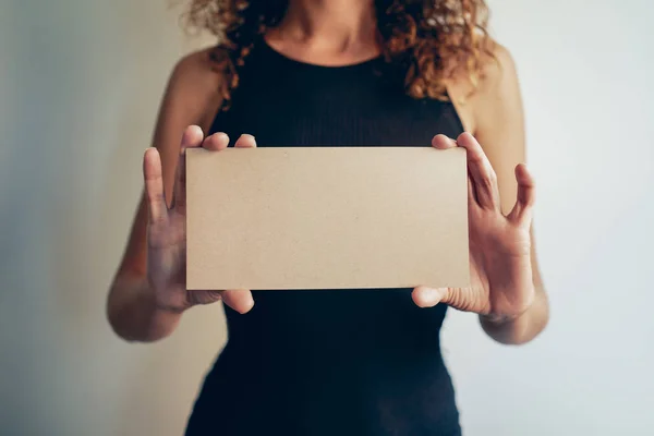 Young woman holding blank envelope in hands