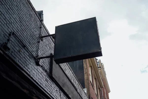 blank signboard on street. Black square signboard on the black brick wall