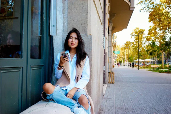 Junge Asiatin Sitzt Modernem Café Und Benutzt Smartphone — Stockfoto